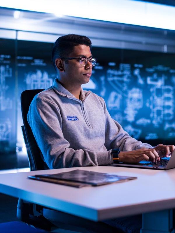 A student works on an assignment at his automotive co-op job.