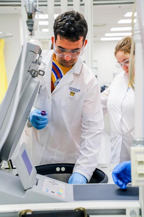 Students working in a chemistry lab's centrifuge.